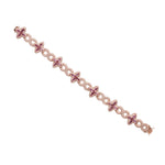 long side view of rose gold bracelet with star-shaped charms on a white background