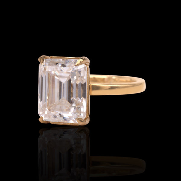 Gold ring with a large rectangular diamond on a black background