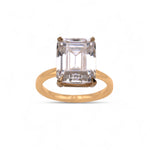 Gold ring with a large rectangular gemstone on a white background